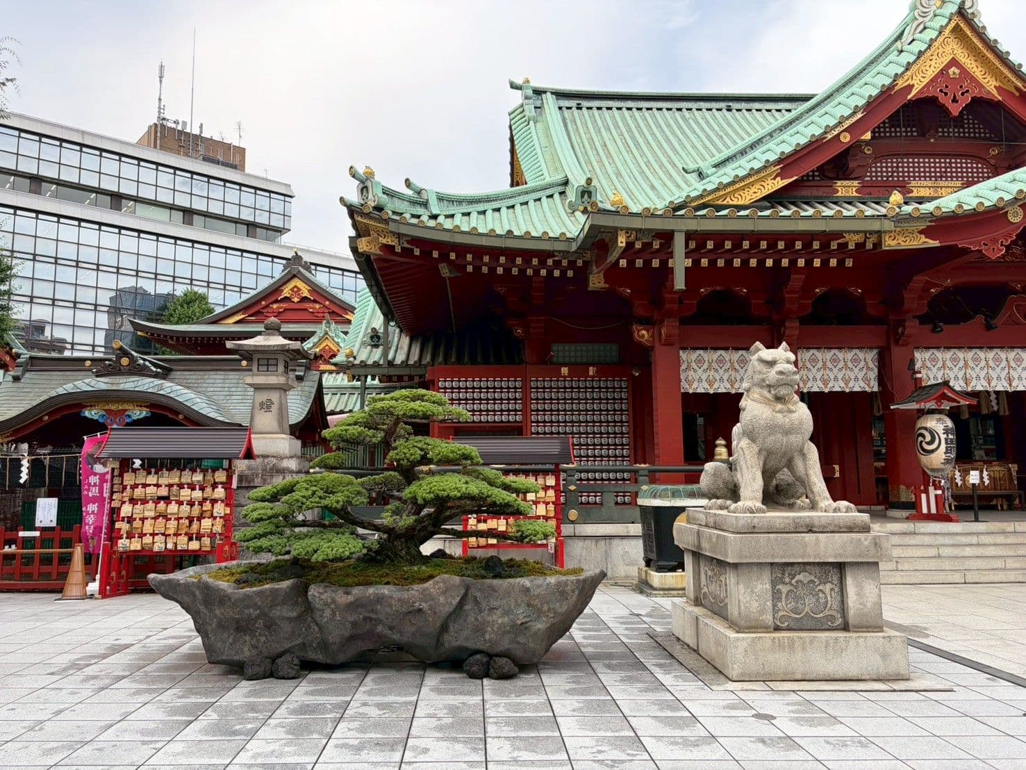 Fukei bonsai beside a guardian lion-dog in the shrine grounds