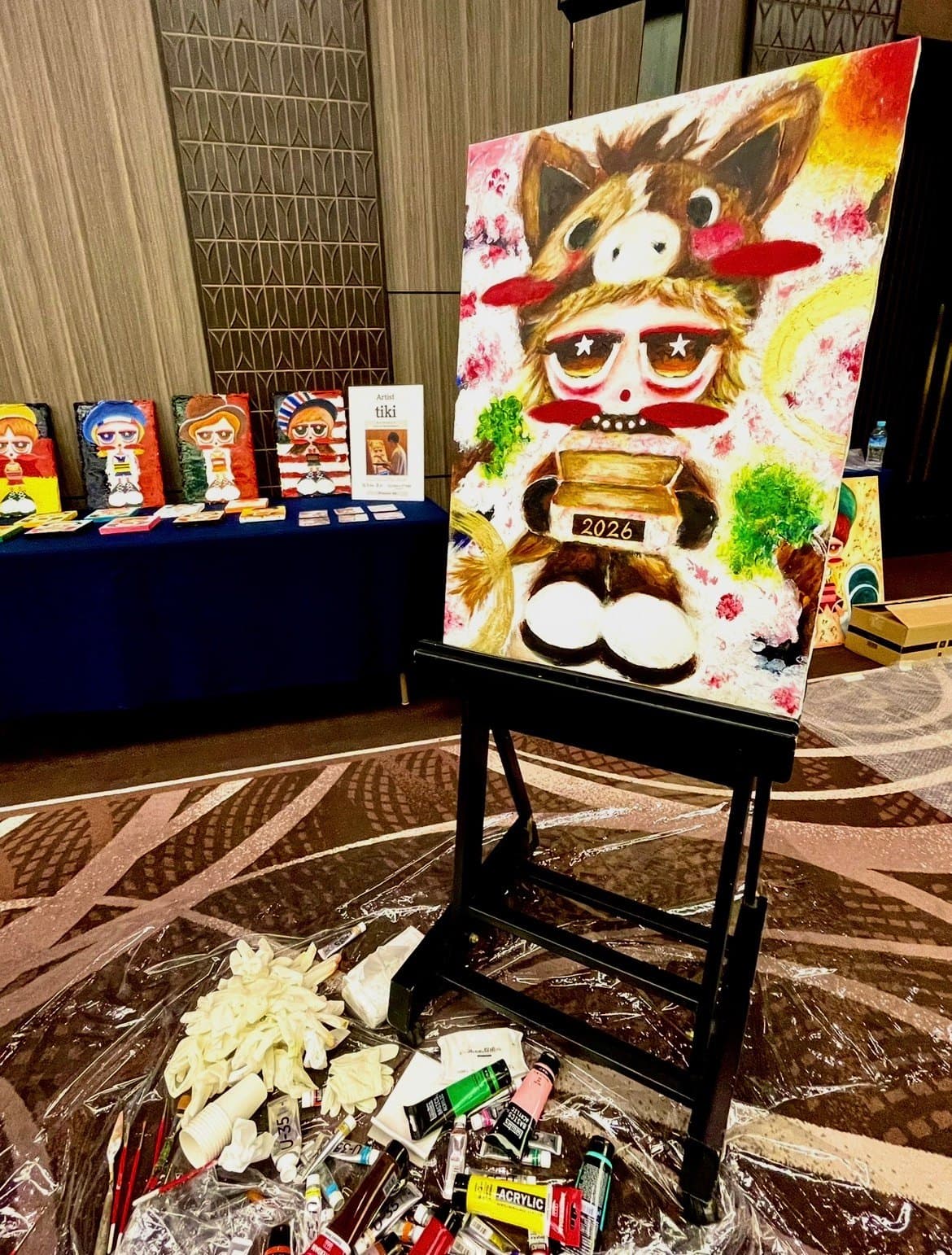 A large work on an easel, with more works beyond