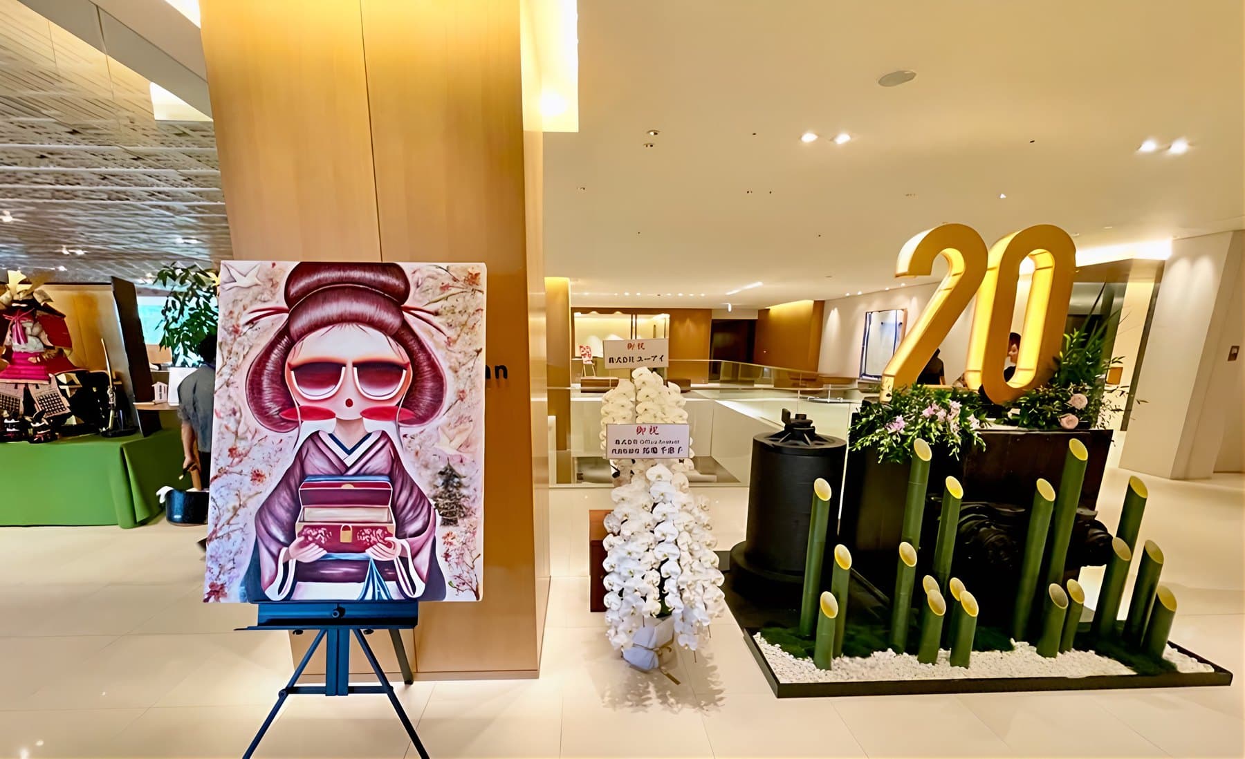 ロビーの展示。着物姿の子どもを描いた作品が、「20」の飾りの隣に立つ