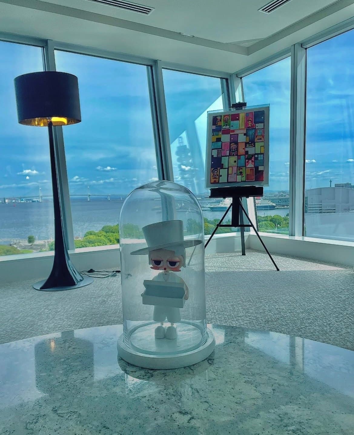 海を望む窓辺に、ガラスのドームの立体とイーゼルの作品