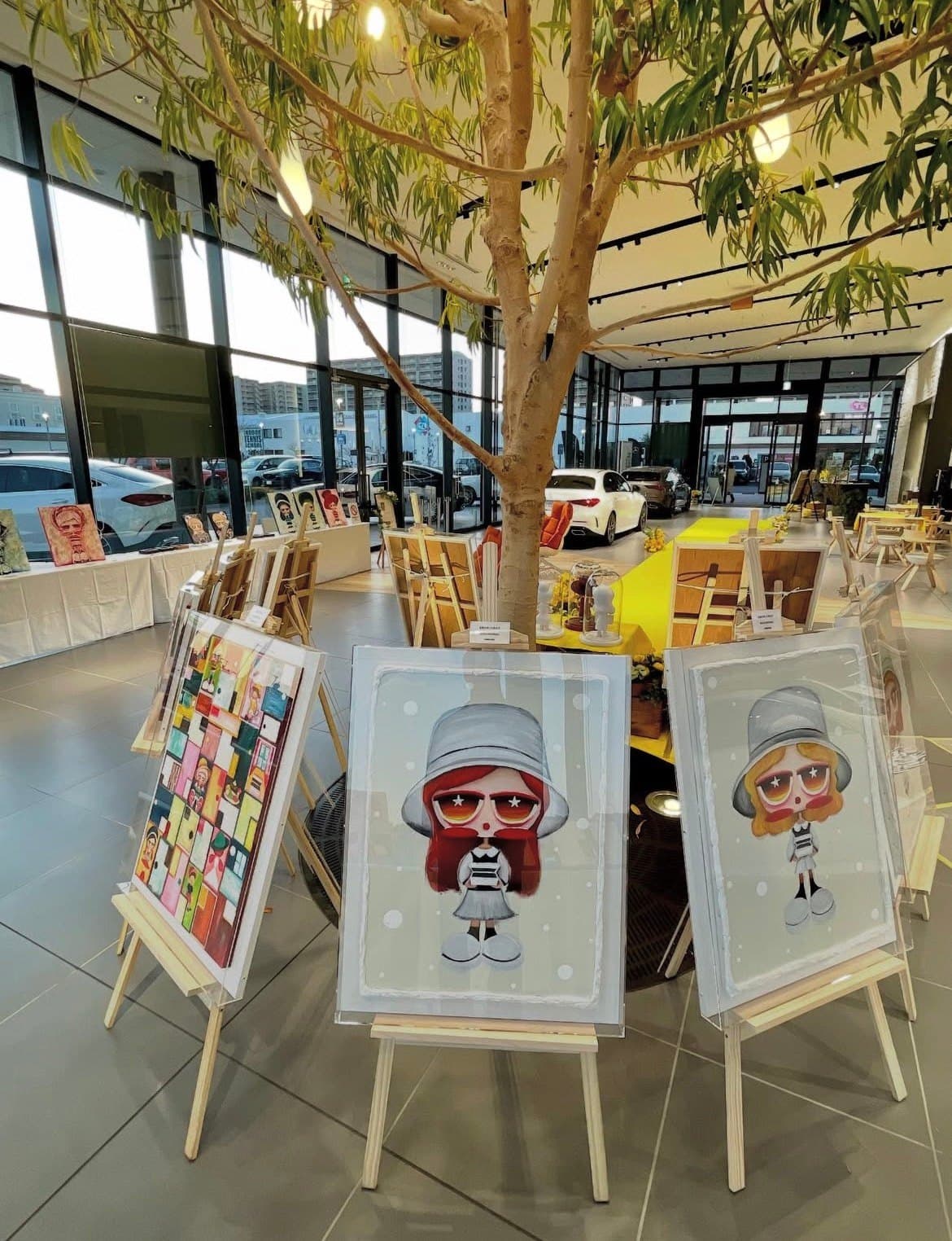 Works on easels, set out beneath the tree in the showroom