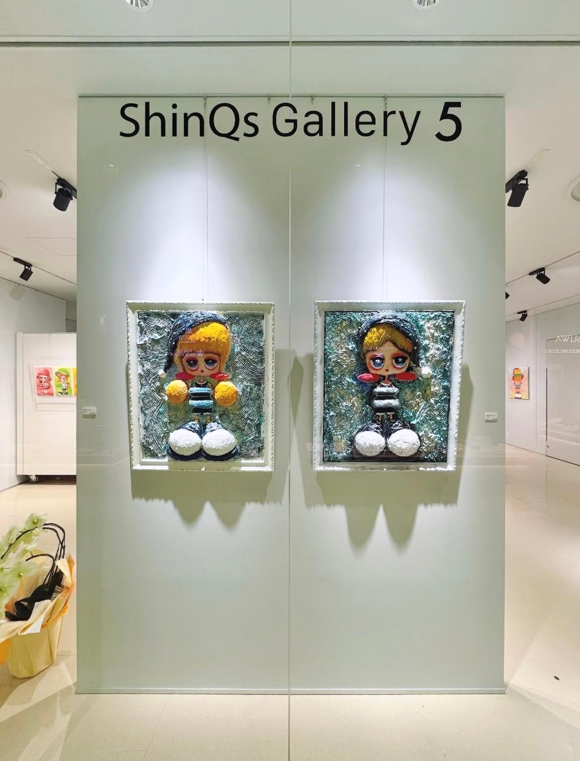 The entrance to ShinQs Gallery 5, Shibuya Hikarie, with two sculptural works hung on the wall